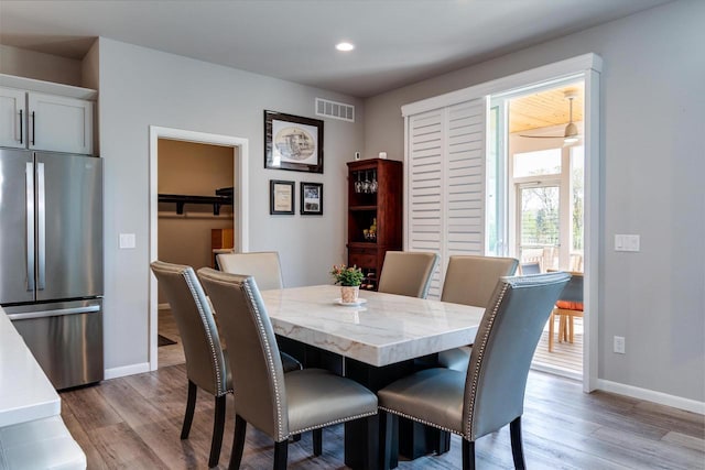 dining space with light wood finished floors, baseboards, and recessed lighting