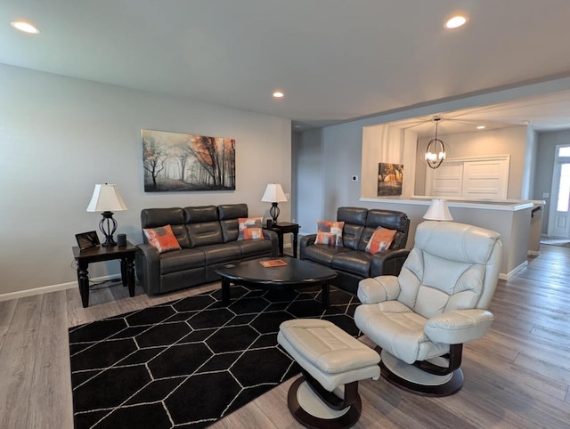 living area with wood finished floors, baseboards, recessed lighting, and a chandelier