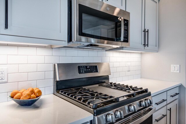 kitchen featuring stainless steel appliances, tasteful backsplash, and light countertops