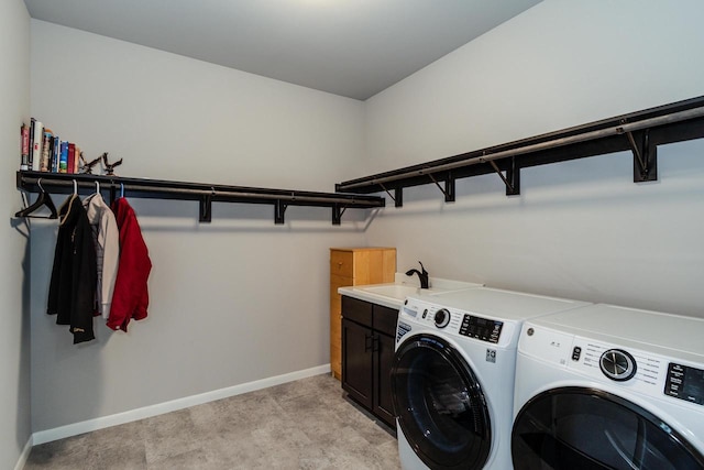 laundry area featuring cabinet space, washer and clothes dryer, and baseboards