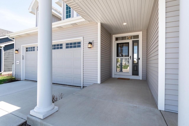 doorway to property featuring concrete driveway and an attached garage