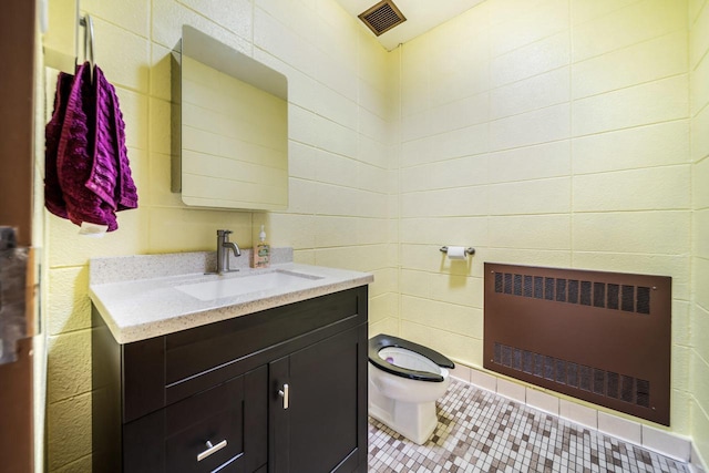 510 Lake St, Cascade, WI 53011 - bathroom with tile patterned flooring, vanity, toilet, radiator heating unit, and visible vents