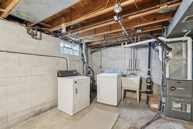 below grade area with visible vents, a sink, and washing machine and dryer