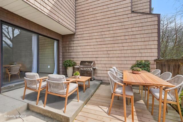wooden terrace with outdoor dining area and grilling area