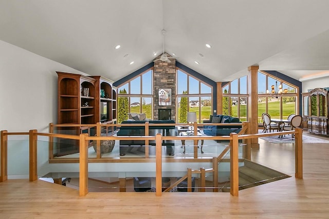 living area with wood finished floors, recessed lighting, and high vaulted ceiling