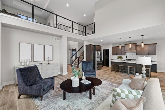 N59W27328 Autumn Ct, Lisbon, WI 53089 - living area featuring stairway, a towering ceiling, light wood finished floors, and visible vents