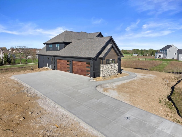 N59W27328 Autumn Ct, Lisbon, WI 53089 - view of side of home with a garage, cooling unit, driveway, and a shingled roof