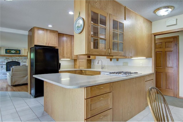 1897 Breezy Bay Rd, Balsam Lake, WI 54810 - kitchen with white gas cooktop, light tile patterned flooring, light countertops, freestanding refrigerator, and glass insert cabinets