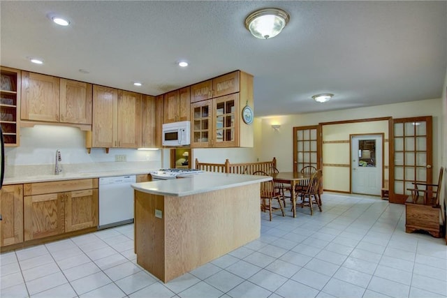 1897 Breezy Bay Rd, Balsam Lake, WI 54810 - kitchen with open shelves, white appliances, glass insert cabinets, light countertops, and a sink
