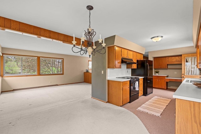 kitchen with light colored carpet, black appliances, under cabinet range hood, a baseboard radiator, and an inviting chandelier