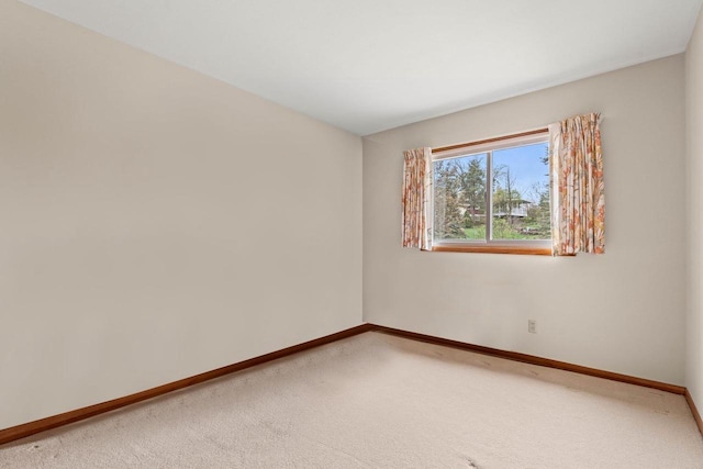 empty room featuring baseboards and carpet floors