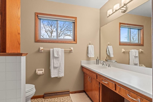 bathroom featuring toilet, a wealth of natural light, baseboards, and visible vents