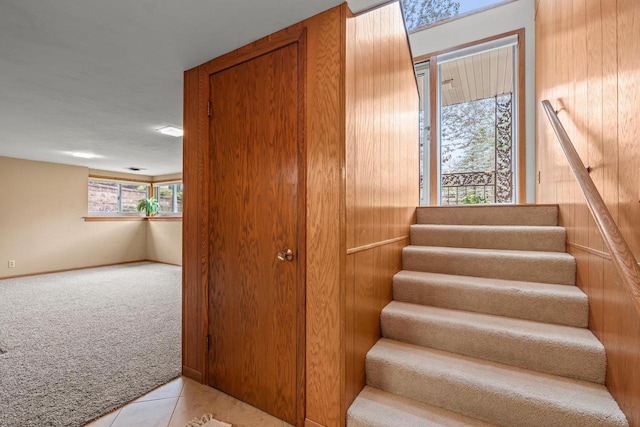 staircase with baseboards, tile patterned floors, and carpet floors