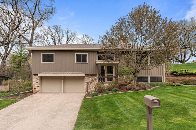 split foyer home featuring an attached garage, concrete driveway, a front yard, brick siding, and roof with shingles