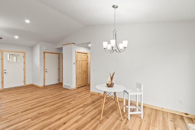 dining room featuring a notable chandelier, light wood-style floors, baseboards, lofted ceiling, and visible vents