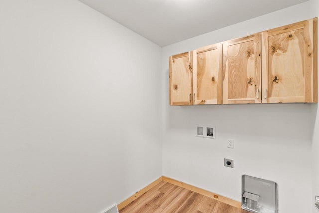 clothes washing area with baseboards, hookup for a washing machine, light wood-type flooring, cabinet space, and hookup for an electric dryer