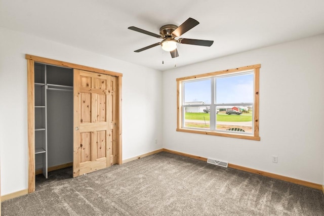 unfurnished bedroom featuring carpet floors, a ceiling fan, baseboards, visible vents, and a closet
