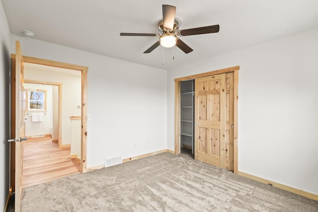 unfurnished bedroom with ceiling fan, carpet floors, baseboards, visible vents, and a closet