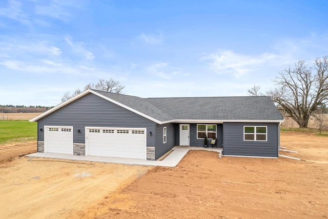 ranch-style house featuring stone siding, driveway, roof with shingles, and a garage