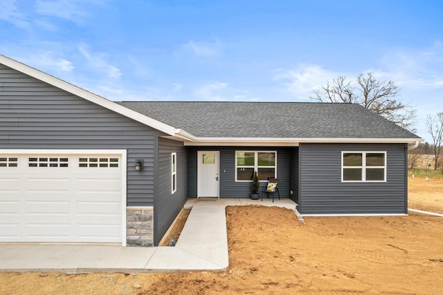 ranch-style home featuring roof with shingles and an attached garage