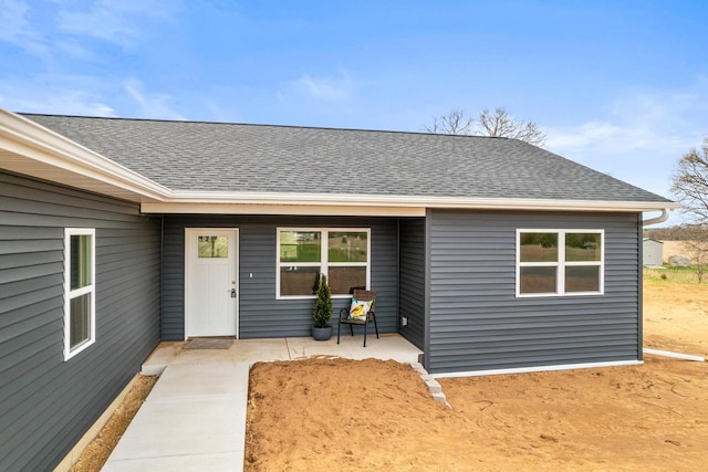 entrance to property with roof with shingles