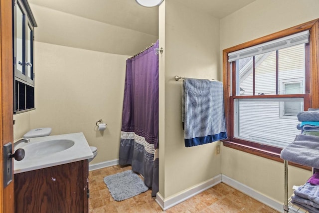 full bath with baseboards, curtained shower, and vanity