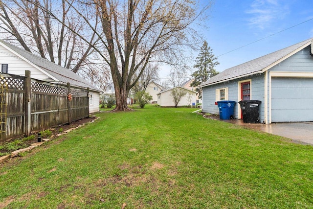view of yard featuring fence and a detached garage