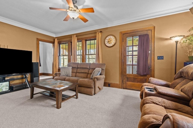 carpeted living room featuring crown molding, a ceiling fan, and baseboards