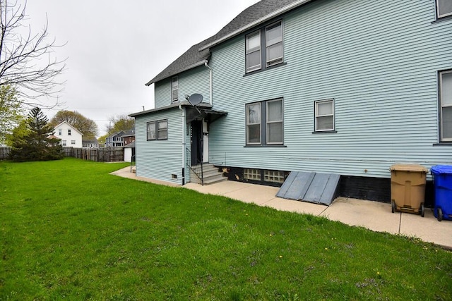 back of house with a lawn, fence, and entry steps