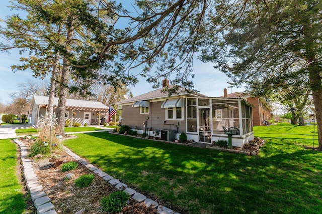556 Gold St, Green Lake, WI 54941 - rear view of property with a lawn, a sunroom, a chimney, and central AC unit