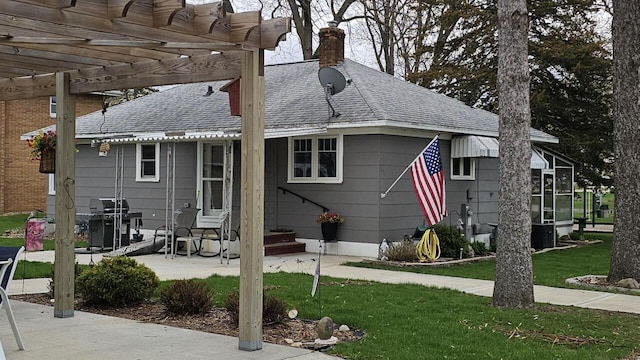 556 Gold St, Green Lake, WI 54941 - rear view of property with a pergola, a chimney, a yard, and a shingled roof
