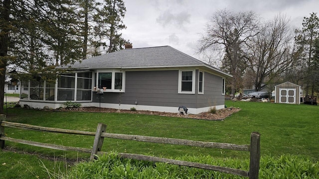 556 Gold St, Green Lake, WI 54941 - view of side of property with a storage shed, a shingled roof, a chimney, an outdoor structure, and a sunroom