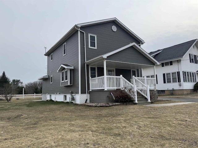 traditional home featuring covered porch and a front lawn