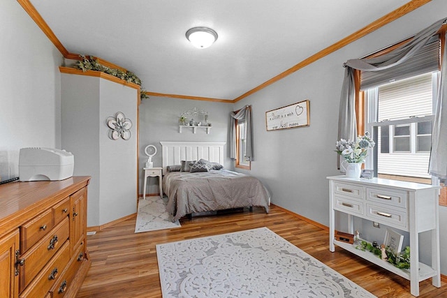 bedroom with crown molding, light wood-style flooring, and baseboards