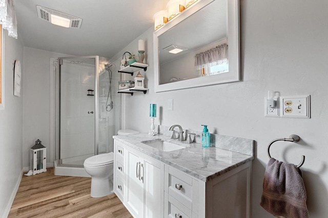 full bathroom featuring toilet, wood finished floors, vanity, visible vents, and a stall shower