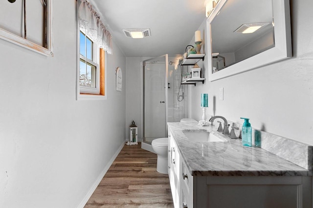 full bath with toilet, wood finished floors, a stall shower, visible vents, and vanity