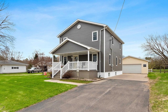 view of front of house featuring a porch, a garage, an outbuilding, and a front yard