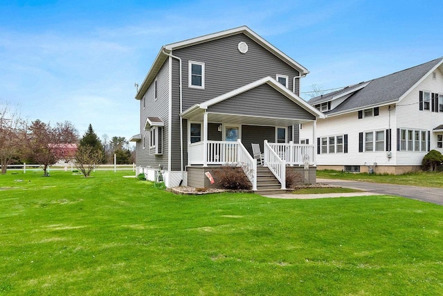 traditional-style home featuring a front yard and covered porch
