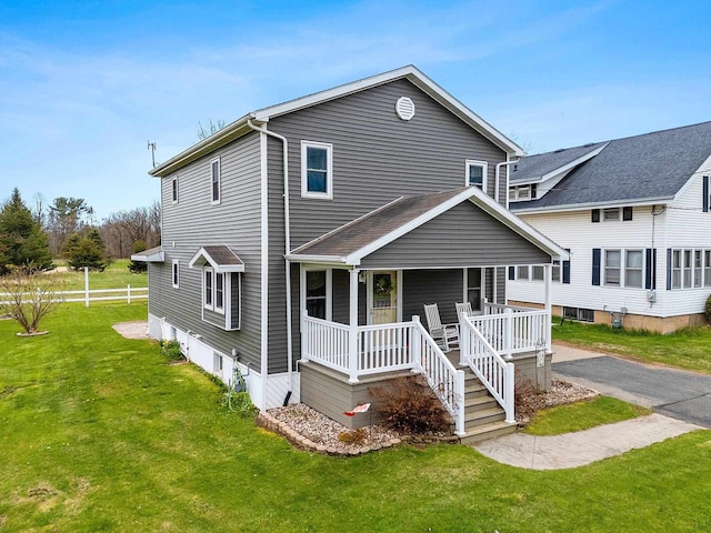 view of front of property featuring a front yard and covered porch