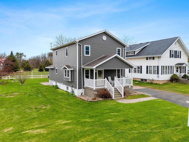 traditional-style home with covered porch and a front lawn
