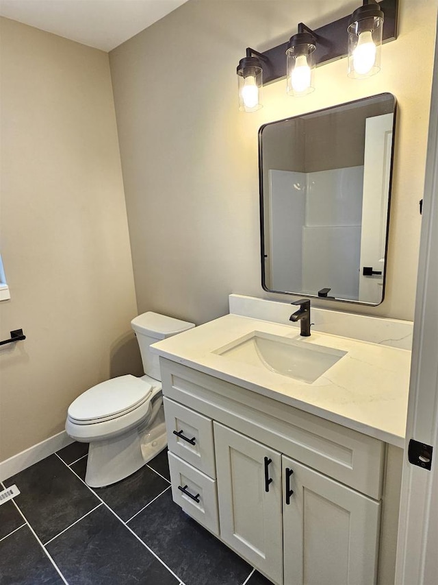 bathroom with vanity, tile patterned flooring, and toilet