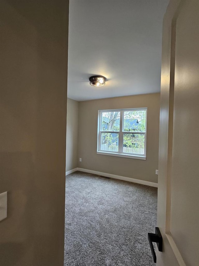 empty room with baseboards and carpet