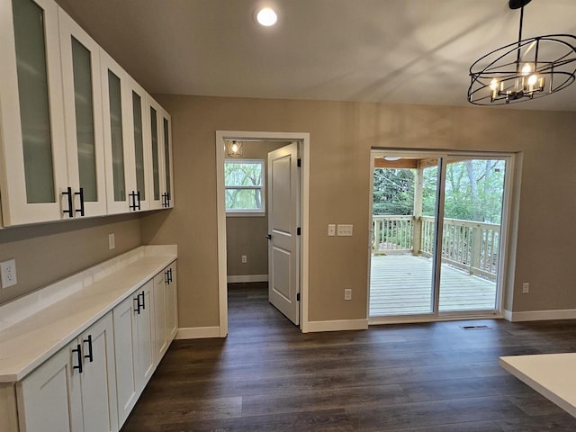interior space with baseboards, recessed lighting, dark wood finished floors, and an inviting chandelier