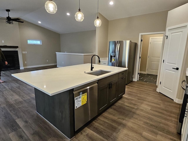 kitchen with dark wood-style flooring, ceiling fan, light countertops, a sink, and appliances with stainless steel finishes