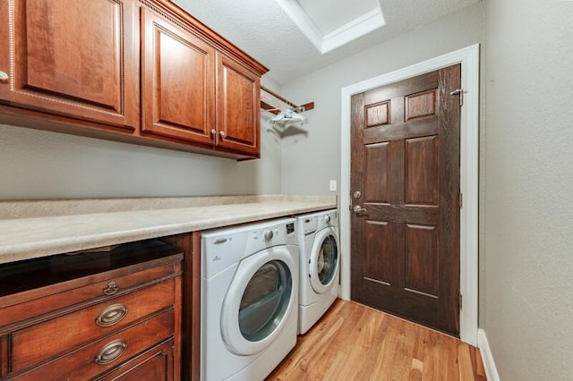 washroom with light wood-style floors, cabinet space, and independent washer and dryer