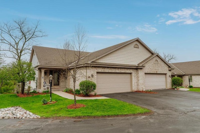 view of front facade with a garage, a front lawn, brick siding, a shingled roof, and driveway