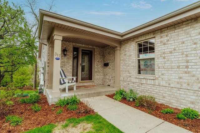 entrance to property with brick siding and covered porch