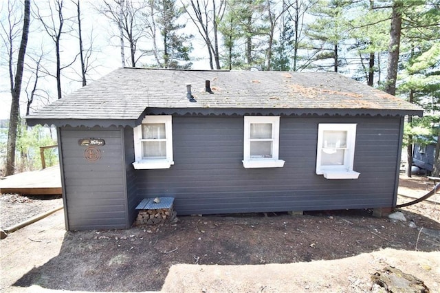 view of property exterior with a shingled roof