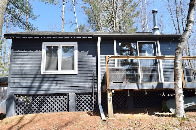 rear view of house with cooling unit and a wooden deck