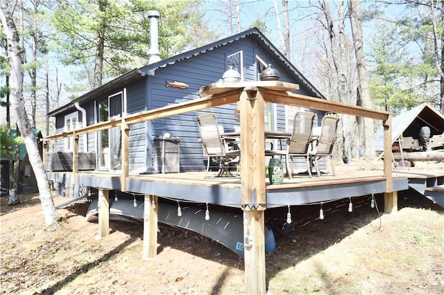 rear view of house featuring a wooden deck